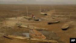 A Kashmiri woman works as she sits inside a boat at a dried portion of Wular Lake, northeast of Srinagar, Indian-controlled Kashmir, Oct. 29, 2016.