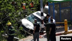 Pasukan keamanan Israel dan petugas darurat memeriksa lokasi terjadinya kecelakaan mobil yang dikemudikan oleh warga Palestina di dekat permukiman penduduk kawasan Ofra, Ramalah, Tepi Barat, 6 April 2017. (REUTERS/Mohamad Torokman)