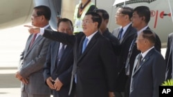 រូបឯកសារ៖ លោក​នាយក​រដ្ឋ​មន្ត្រី ហ៊ុន សែន (កណ្តាល) ជូន​ដំណើរព្រះបាទ​ នរោត្តម សីហមុន្នី នៅ​អាកាសយានដ្ឋាន​អន្តរជាតិ​ភ្នំពេញ កាលពី​ថ្ងៃច័ន្ទ ទី១៩ ខែ​តុលា ឆ្នាំ​២០១៥។ (AP/ហេង ស៊ីនិត)