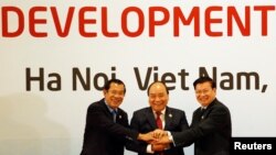 រូបឯកសារ៖ លោក​នាយករដ្ឋ​មន្ត្រី ហ៊ុន សែន (ឆ្វេង) លោកនាយករដ្ឋមន្ត្រីវៀតណាម Nguyen Xuan Phuc (កណ្តាល) និងលោកនាយករដ្ឋមន្ត្រីឡាវ Thongloun Sisoulith ថតរូបរួមគ្នាមួយមុនកិច្ចប្រជុំលើកទី១០រវាងកម្ពុជា ឡាវ និងវៀតណាម ដែលជាផ្នែកមួយនៃកិច្ចប្រជុំអនុតំបន់មេគង្គ នៅទីក្រុងហាណូយ ប្រទេសវៀតណាម កាលពីថ្ងៃទី៣១ ខែមិនា ឆ្នាំ២០១៨។