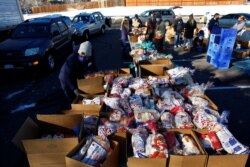 FILE - People line up in their cars in the parking lot of St. James Presbyterian Church in Littleton, Colorado, to receive food donations from Food Bank of the Rockies ahead of Thanksgiving, Nov. 25, 2020.