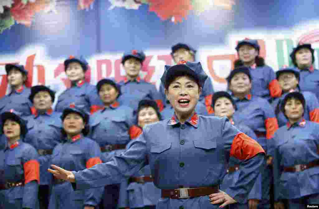Retired female workers dressed as red army soldiers sing revolutionary songs during a performance to mark the 120th birth anniversary of Mao Zedong in Huaibei, Anhui province, China, Dec. 26, 2013. 