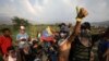 Venezuelan migrants near the Simon Bolivar International Bridge plead for people to support them with food and water so they can continue protesting in La Parada near Cucuta, Colombia, Sunday, Feb. 24, 2019, on the border with Venezuela.