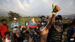 Venezuelan migrants near the Simon Bolivar International Bridge plead for people to support them with food and water so they can continue protesting in La Parada near Cucuta, Colombia, Sunday, Feb. 24, 2019, on the border with Venezuela.