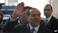 Former Italian Prime Minister Silvio Berlusconi arrives at the central train station, Milan, Dec. 29, 2012.