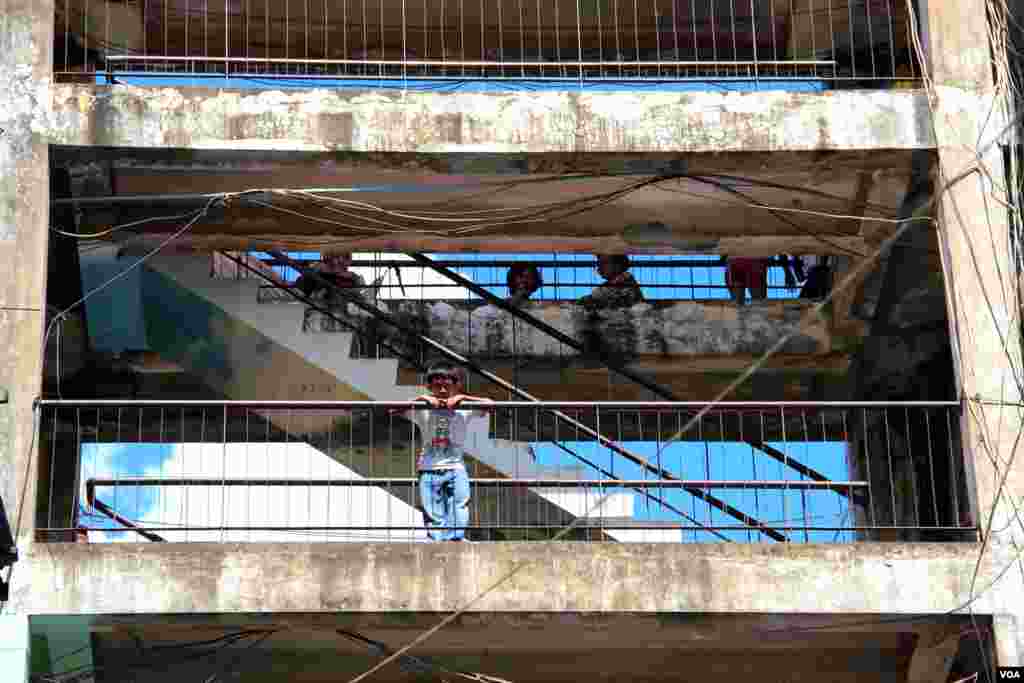 ទិដ្ឋភាព​ជា​ទូទៅ​នៃ​អគារ​ប៊ូលឌីង​និង​អ្នក​រស់​នៅ​ក្នុង​អគារ​ប៊ូលឌីង​ក្នុង​រាជធានី​ភ្នំពេញ​កាល​ពី​ថ្ងៃ​សុក្រ​ទី​៥ ខែ​កញ្ញា ឆ្នាំ​២០១៤។ (នូវ ពៅលក្ខិណា/VOA)