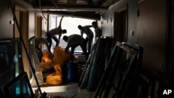 Workers remove debris from the Saint George Hospital, heavily damaged in last week's massive explosion in Beirut, Lebanon, Thursday, Aug. 13, 2020. (AP Photo/Felipe Dana)