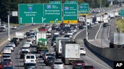 FILE - Traffic travels on Interstate 75, in Forrest Park, south of Atlanta, Sept. 8, 2017. The U.S. Department of Justice sued EZ Lynk on March 8, 2021, for selling devices that allow drivers to disable their vehicles' computerized emission controls.