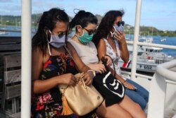 Passengers wearing protective face masks travel by boat to Petite-Terre on the French Indian Ocean island of Mayotte on June 5, 2020.