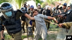 FILE - Police detain a supporter of Pakistan's former Prime Minister Imran Khan who with others was protesting against Khan's arrest, in Lahore, Pakistan, May 10, 2023.