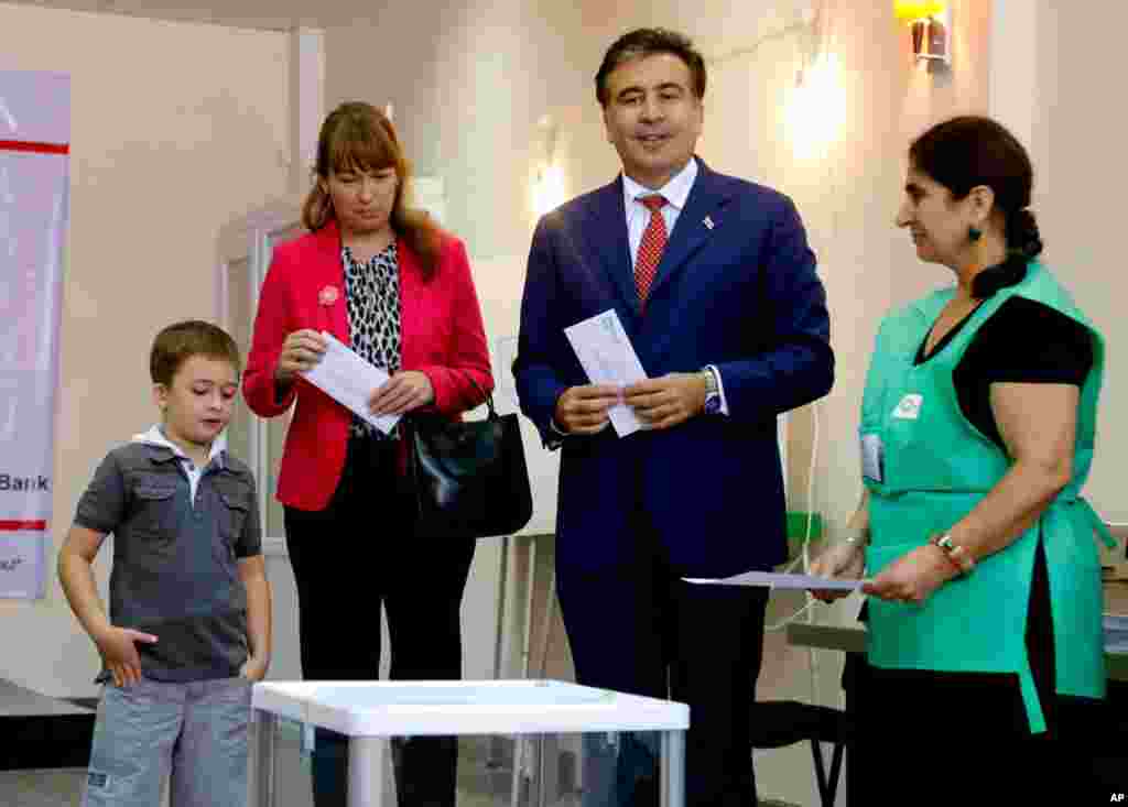 Georgian President Mikheil Saakashvili, his wife Sandra Roelofs, and his son Nikoloz at a ballot box before voting in Tblisi, October 1, 2012.