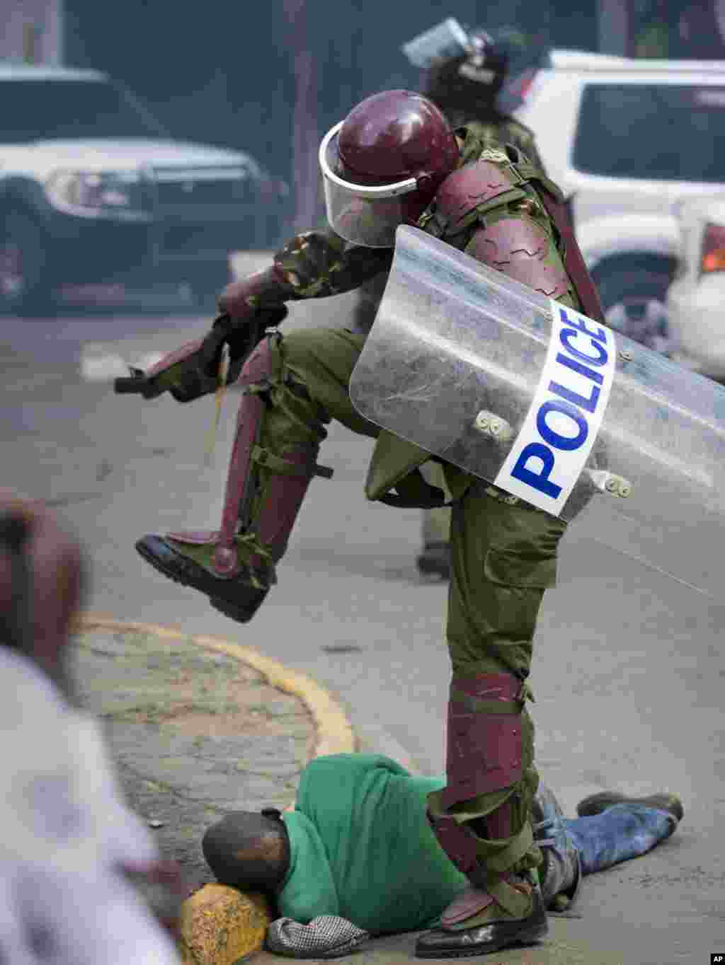 A Kenyan riot policeman repeatedly kicks a protester in downtown Nairobi, May 16, 2016. Police tear-gassed and beat opposition supporters during a protest demanding the disbandment of the electoral authority over alleged bias and corruption.