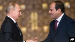 Russian President Vladimir Putin, left, Egyptian President Abdel-Fattah El-Sissi, shake hands after a news conference following their talks in Cairo, Egypt, Dec. 11, 2017. 