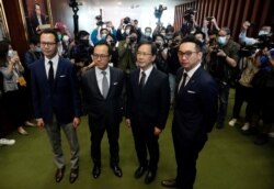 Four lawmakers, from left, Dennis Kwok, Kenneth Leung, Kwok Ka-ki and Alvin Yeung pose after a press conference at the Legislative Council in Hong Kong Wednesday, Nov. 11, 2020. Hong Kong has moved to disqualify the four pro-democracy legislators…