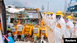 Members of a Fukushima prefecture panel, which monitors the safe decommissioning of the nuclear plant, inspect the construction site of the shore barrier, Aug. 6, 2013.