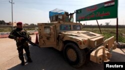 Iraqi army members stand guard at the entrance to the Nineveh Liberation Operations Command at Makhmour base, south of Mosul, Iraq, March 13, 2016.