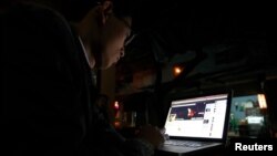 រូបឯកសារ៖ សកម្មជនវៀតណាមដើម្បីសេរីភាពតាមប្រព័ន្ធអ៊ីនធឺណិតម្នាក់ សរសេរនៅលើគណនីហ្វេសប៊ុកនៅហាងកាហ្វេមួយក្នុងទីក្រុងហាណូយ ប្រទេសវៀតណាម កាលពីថ្ងៃទី២៧ ខែវិច្ឆិកា ឆ្នាំ២០១៣។