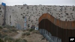 FILE - A border fence separates the towns of Anapra, Mexico, and Sunland Park, New Mexico, Nov. 10, 2016. 