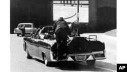 Клин Хилл на автомобиле Кеннеди вскоре после выстрелов, ставших для президента смертельными, Даллас, 22 ноября 1963