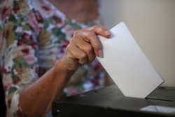 A woman casts her ballot at a polling station in Lisbon, Oct. 6, 2019.