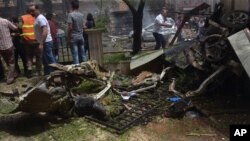 Warga dan petugas pemadam kebakaran berkumpul di lokasi jatuhnya roket yang menimpa rumah sakit Dubeet hospital di pusat daerah Muhafaza di Aleppo, Suriah (3/5).