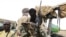 FILE - Militiaman from the Ansar Dine Islamic group sit on a vehicle in Gao, in northeastern Mali, June 18, 2012. 