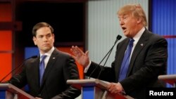 Republican U.S. presidential candidate Marco Rubio listens as rival candidate Donald Trump speaks at the U.S. Republican presidential candidates debate in Detroit, Michigan, March 3, 2016.