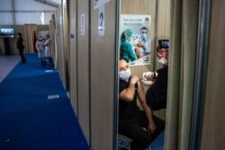 FILE - A Moroccan nurse administers the AstraZeneca COVID-19 vaccine to a health worker, on the first day of vaccination campaign, in Rabat, Jan. 29, 2021.