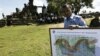 In this photo taken Nov. 7, 2008, a Cambodian deminer, holds a map of a disputed border at an entrance of Cambodia's Preah Vihear temple in a world heritage site near the Cambodian-Thai border.