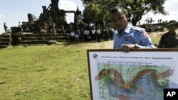 In this photo taken Nov. 7, 2008, a Cambodian deminer, holds a map of a disputed border at an entrance of Cambodia's Preah Vihear temple in a world heritage site near the Cambodian-Thai border.