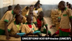 FILE - Students learn with the help of a computer tablet provided by UNICEF at a school in Baigai, northern Cameroon, Tuesday 31 October 2017. 