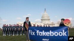 Avaaz campaigners stage 100 cardboard cutouts of Facebook CEO Mark Zuckerberg to draw attention to millions of fake accounts still spreading disinformation on the social media platform, Washington, April 2018.