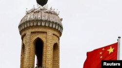 រូបឯកសារ៖ ទង់ជាតិ​ចិន​បក់​រវិចៗនៅ​ជិត​​វិហារ​សាសនា​ឥស្លាម​មួយ​ក្នុង​តំបន់​ Xinjiang ដែល​ជា​តំបន់​ស្វ័យភាព​របស់​ជនជាតិ​ភាគតិច Uighur ក្នុង​ប្រទេស​ចិន ថ្ងៃទី៦ ខែកញ្ញា ឆ្នាំ២០១៨។ 