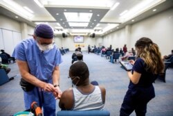 FILE - A health care worker from Humber River Hospital's mobile vaccination team administers the Moderna COVID-19 vaccine at the Church of Pentecost Canada in Toronto, Ontario, May 4, 2021.