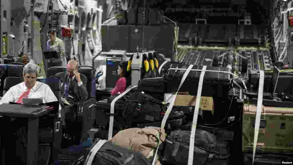 U.S. Secretary of State John Kerry, front left, looks over papers while flying from Jordan to Iraq, Sept. 10, 2014. 
