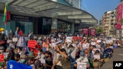 Campaigners display placards at an intersection in Yangon, Myanmar, Feb. 9, 2021. 