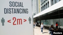 FILE PHOTO: A social distancing sign is seen in Oxford Street, as the outbreak of the coronavirus disease (COVID-19) continues, in London, Britain June 22, 2020. REUTERS/John Sibley/File Photo