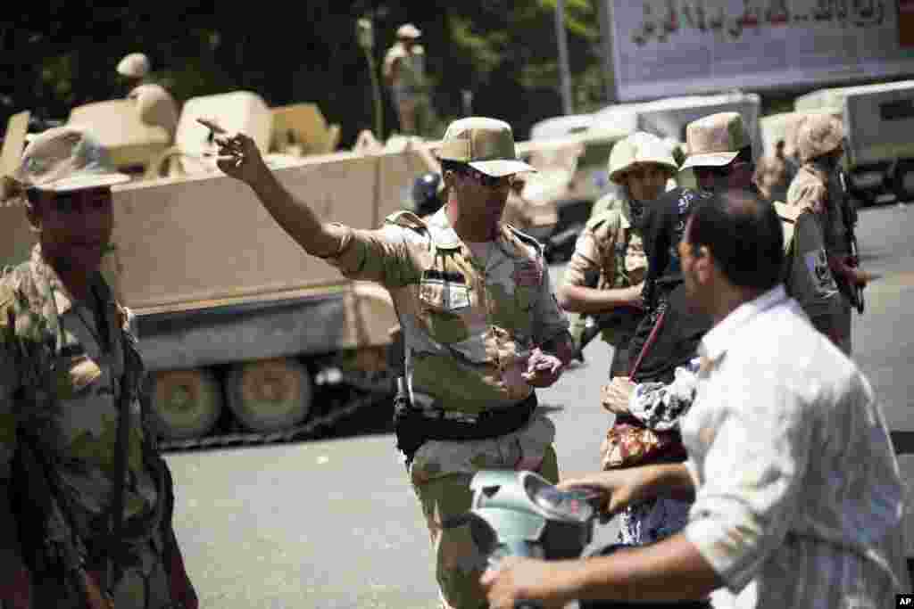 An Egyptian Army commander talks to citizens while securing the area near Cairo University, where Muslim Brotherhood supporters gathered to support ousted president Mohammed Morsi in Cairo, July 4, 2013.