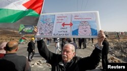 បាតុករប៉ាឡេស្ទីនម្នាក់លើកបដាមួយអំឡុងពេលបាតុកម្មប្រឆាំងនឹងការតាំងទីលំនៅរបស់ជនជាតិជ្វីសនៅតំបន់ West Bank កាលពីថ្ងៃទី២៦ ខែវិច្ឆិកា ឆ្នាំ២០១៩។ 