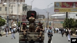 Army soldiers stand guard in a truck as anti-government protesters take part in a demonstration demanding the ouster of Yemen's President Ali Abdullah Saleh in Sana'a, June 3, 2011