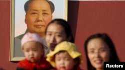 资料照：两名中国妇女抱着她们的孩子在北京天安门毛泽东画像前留影。（2015年11月2日）
