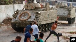 Supporters of Prime Minister-designate Saad Hariri, who stepped down Thursday, clash with Lebanese soldiers in Beirut, Lebanon, July 15, 2021. 