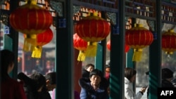 FILE -People rest under decorative lanterns at the Lunar New Year of the Dragon celebration in Beijing on Feb. 13, 2024. A report says the videos promoting Chinese culture are prominent on China's Spanish-language YouTube channels.