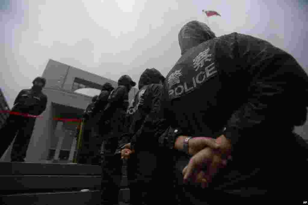 Police officers stand guard at the Hefei City Intermediate People's Court for the murder trial of Gu Kailai, Anhui Province, China, August 9, 2012.