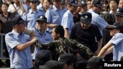 Polisi Tiongkok menangkap seorang pelaku aksi protes menentang perluasan sebuah pabrik kimia di Ningbo, propinsi Zhejiang, Tiongkok (27/10). 