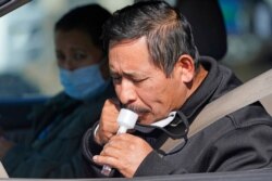 A man takes a COVID-19 saliva test at the University of Utah Health Wellness Bus mobile testing site, in West Valley City, Utah, Oct. 26, 2020.