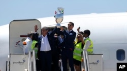 Cristiano Ronaldo et le coach Fernando Santos, (gauche), présentant, après leur victoire sur la France en finale, le trophée de l'Euro 2016 à l'aéroport Humberto Delgado de Lisbon, Portugal, lundi 11 juillet, 2016. (AP Photo/Paulo Duarte)