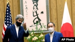 Utusan Iklim AS, John Kerry (kiri) dan PM Jepang Yoshihide Suga di Tokyo, 31 Agustus 2021. (Behrouz Mehri/Pool Photo via AP)