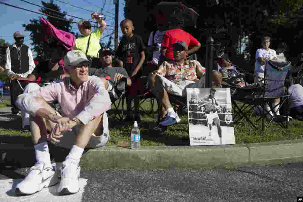 Spectators wait for arrival of Muhammad Ali's funeral procession to enter Cave Hill Cemetery, Louisville, Kentucky, June 10, 2016.
