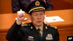 Newly-appointed defense minister Lt. Gen. Wei Fenghe takes the oath of office during a plenary session of China's National People's Congress (NPC) at the Great Hall of the People in Beijing, Monday, March 19, 2018. China on Monday appointed a former missile force commander as its new defense minister amid lingering concerns over the goals of its rapid military modernization. (AP Photo/Mark Schiefelbein)